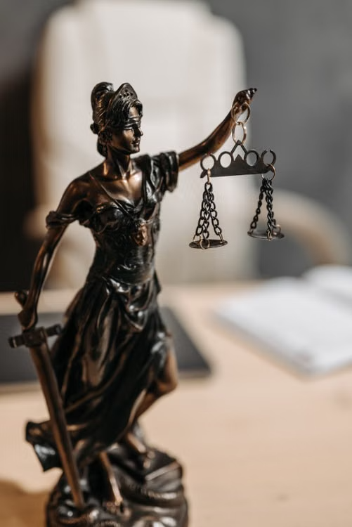 Bronze Lady Justice statue holding scales and a sword.